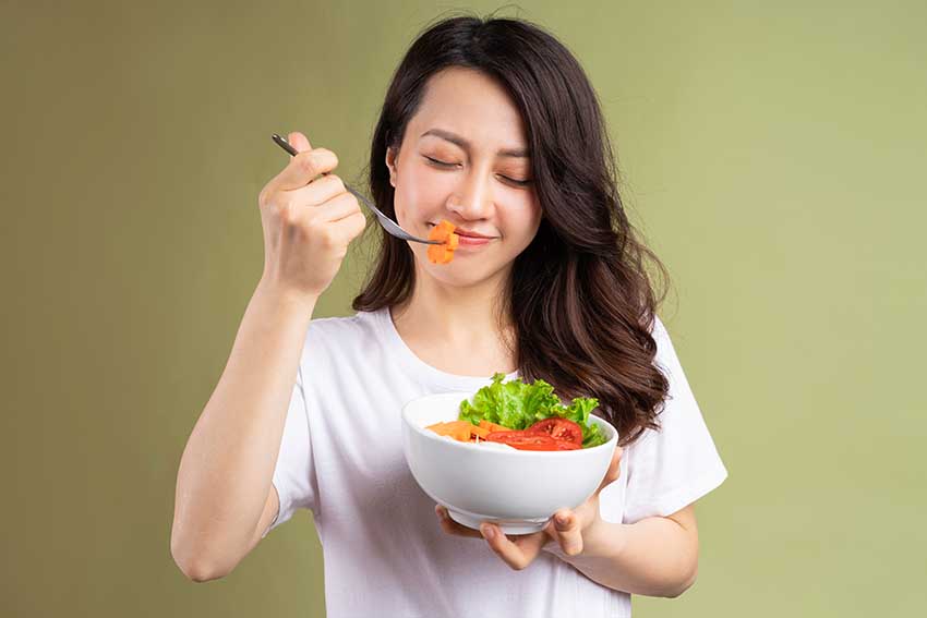 seorang wanita memakan sayur bagus buat kesehatan kulit