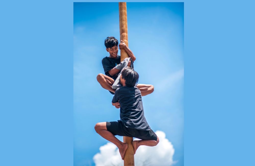 Setiap tahun, lomba panjat pinang selalu berhasil mengundang tawa penonton.