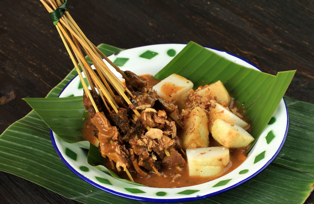 Sate Padang, gurih pedas kuah kentalnya bikin nagih! Daging empuk berpadu sempurna dengan ketupat hangat.