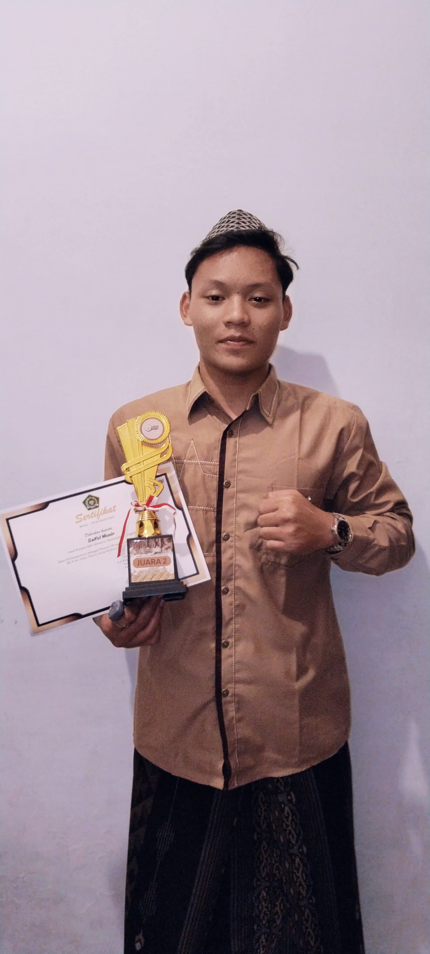 Saiful Munir Membawa piala dan sertifikat Juara 2 MQK tingkat jawa timur
