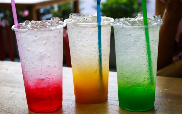Segelas minuman bersoda dengan es batu yang tampak menyegarkan namun menyimpan risiko kesehatan.