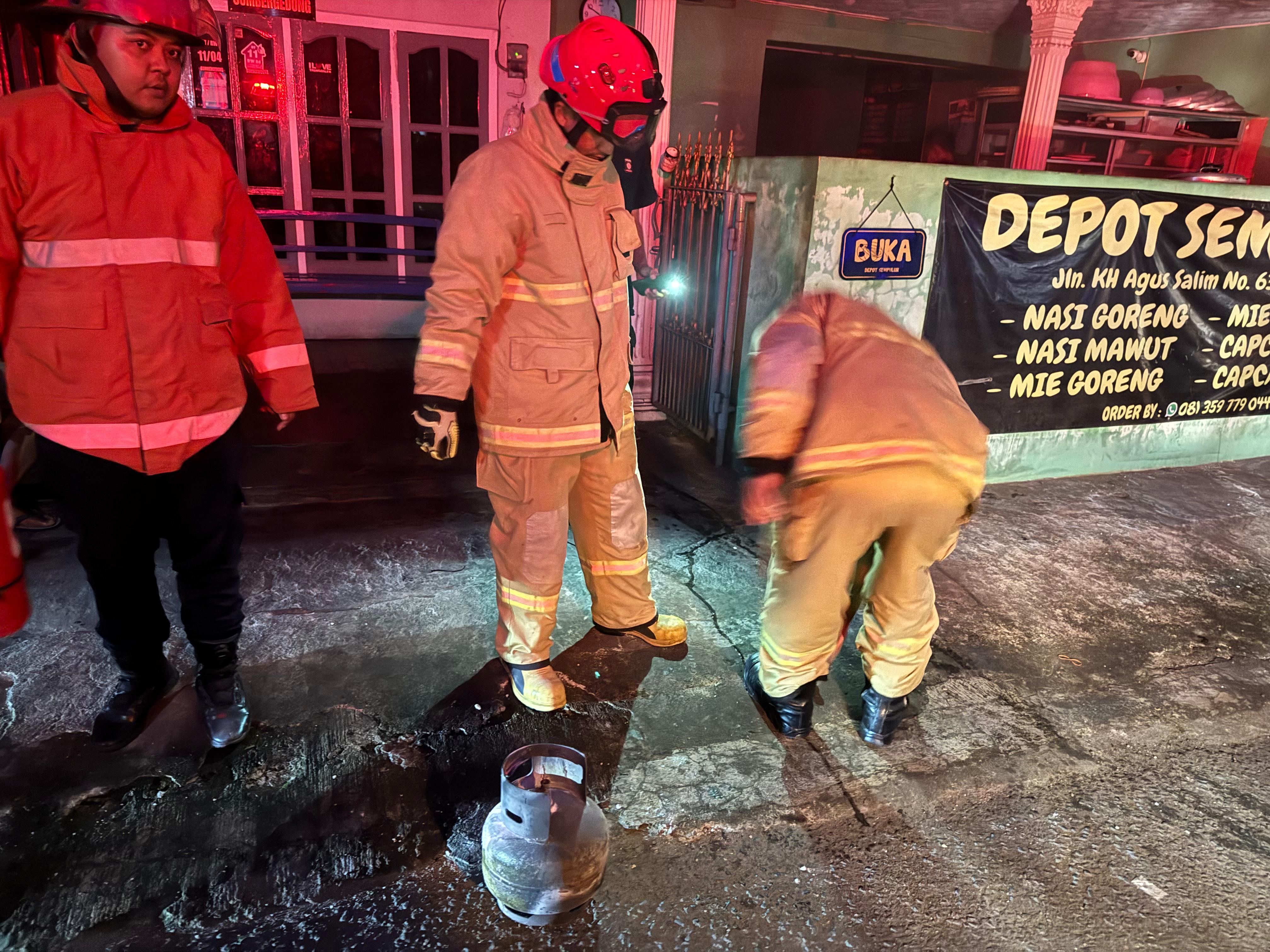 PEtugas Dampar menunjukan penyebab kebakaran di warung nasgor