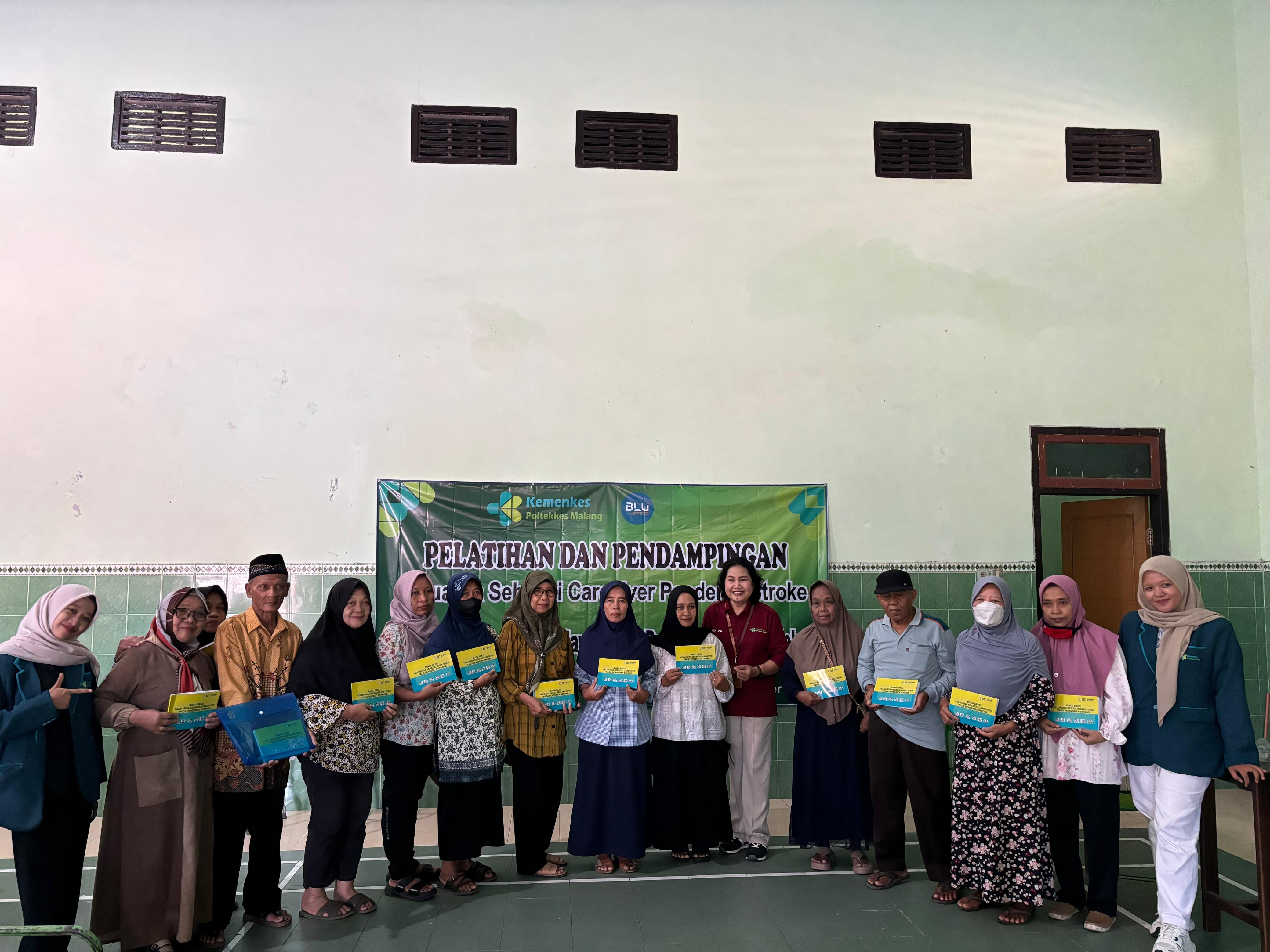 Tim dosen Poltekes Malang yang diketuai Mimik Chirstiani, SST., M.Kes bersama tim memberikan buku saku keluarga sebagai caregiver pada penderita stroke.