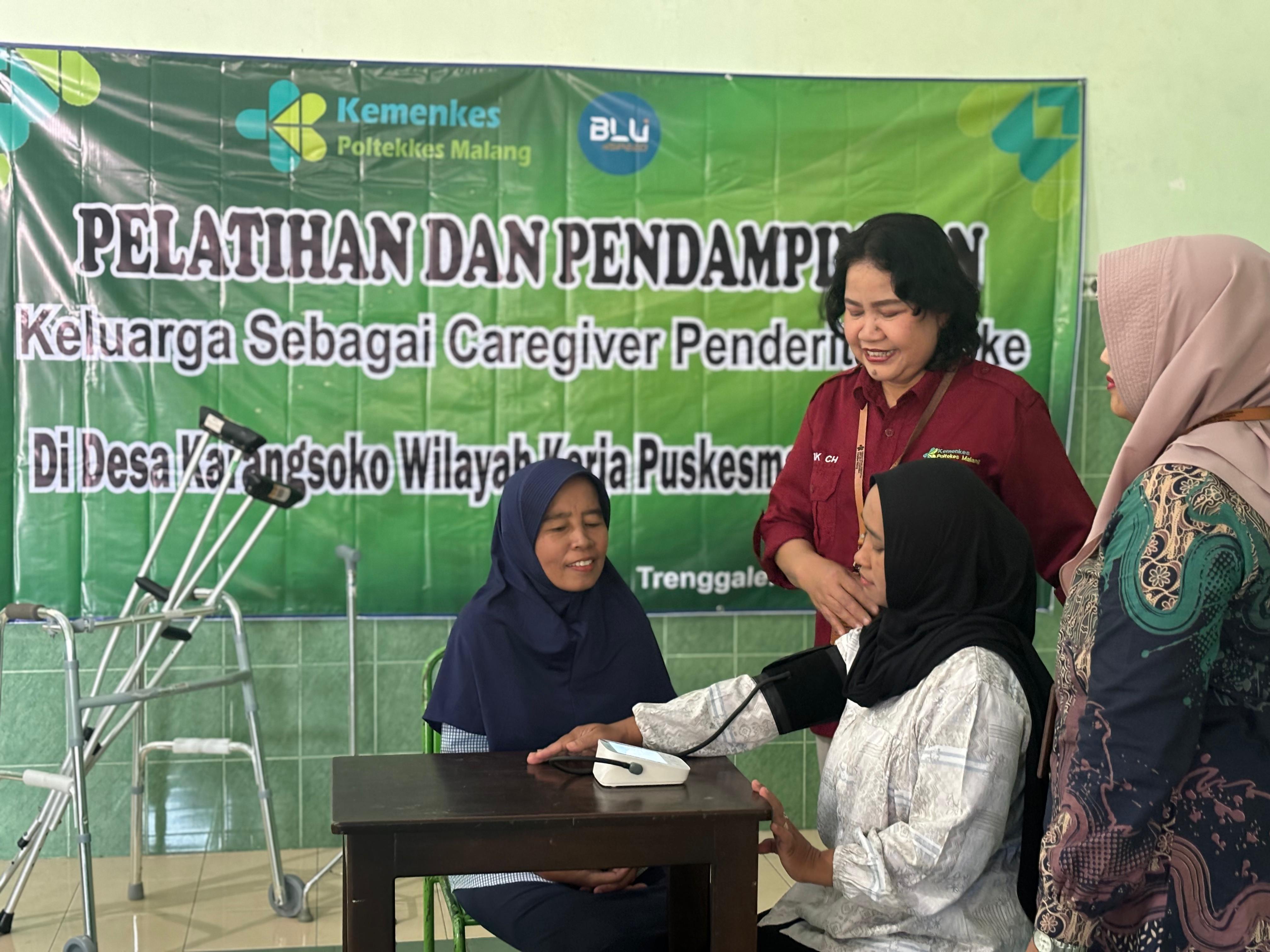 Ketua tim pengabdian Mimik Christiani, SST., M.Kes memberi arahan kepada keluarga penderita stroke.