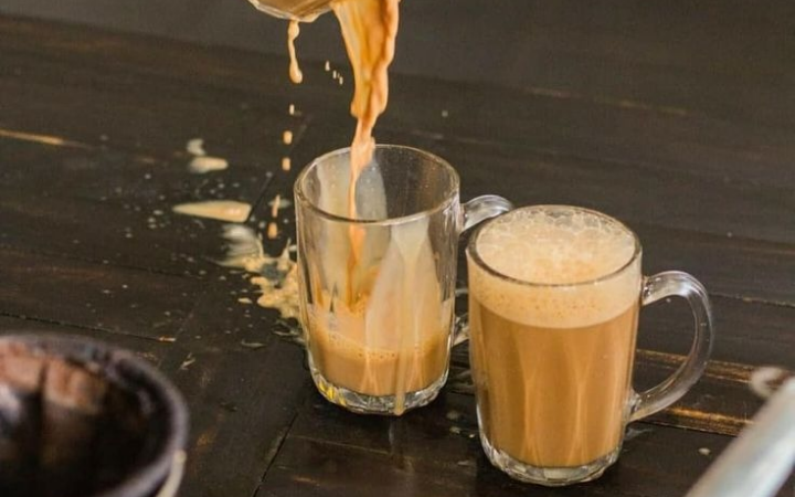 Dua gelas teh tarik hangat dengan busa melimpah di atasnya yang baru dituangkan.