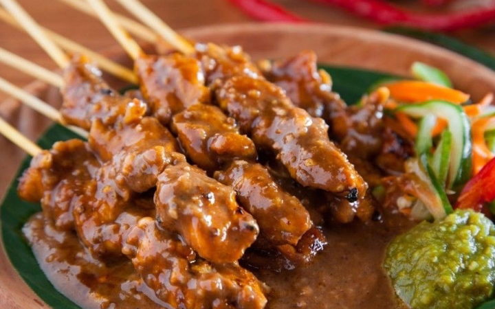 Sate kambing khas Trenggalek dengan bumbu kacang kental, disajikan bersama acar segar dan sambal, menghadirkan cita rasa legendaris.