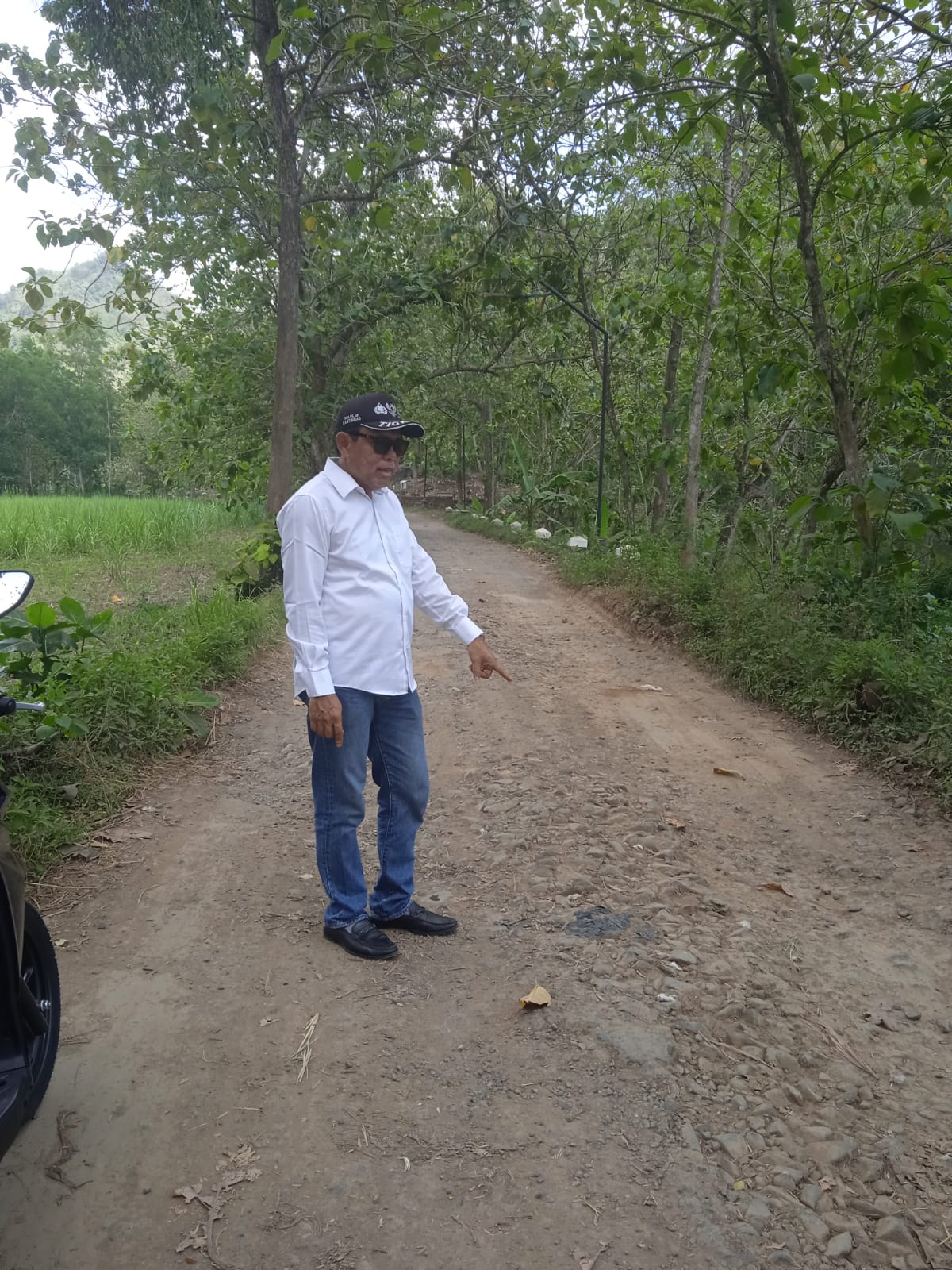 Kades Kamulan, Masruri, saat berada di jalan rusak Desa Kamulan, Kecamatan Durenan, Kabupaten Trenggalek.