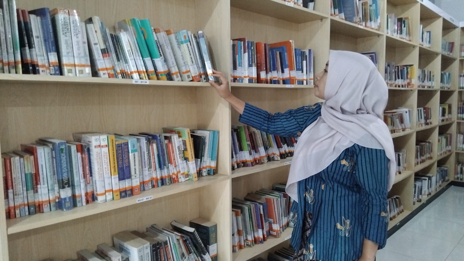 Potret pengunjung Perpustakaan Daerah Trenggalek sedang memilih buku di rak, Kamis (6/11/2025).