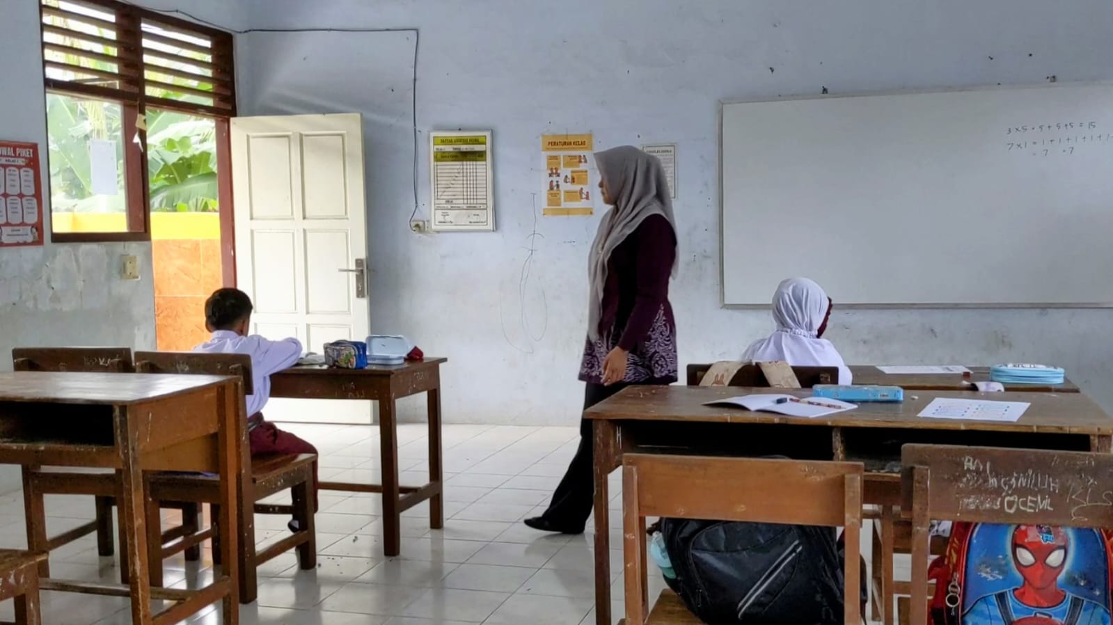Seorang guru di Trenggalek sedang memberikan pelajaran kepada anak didiknya.