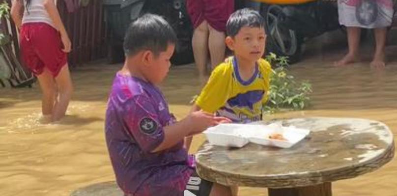 Seorang anak di Padang, Sumatera Barat terlihat menikmati makan bergizi gratis (MBG) di tengah suasana banjir.