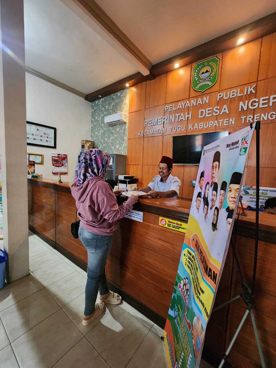 Warga Desa Ngepeh, Kecamatan Tugu, Kabupaten Trenggalek, ketika mengurus surat di balai desa setempat, Rabu (10/12/2025).