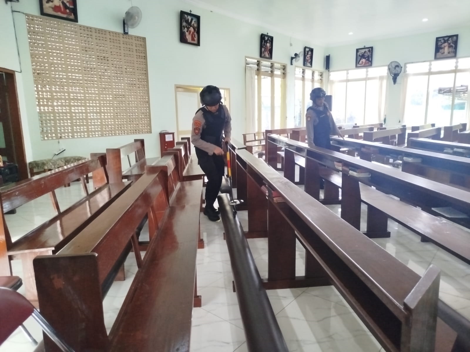 Anggota Polres Trenggalek sedang melakukan sterilisasi di Gereja Santa Maria untuk memastikan tidak ada barang yang bisa mengganggu keamanan, Rabu (24/12/2025).