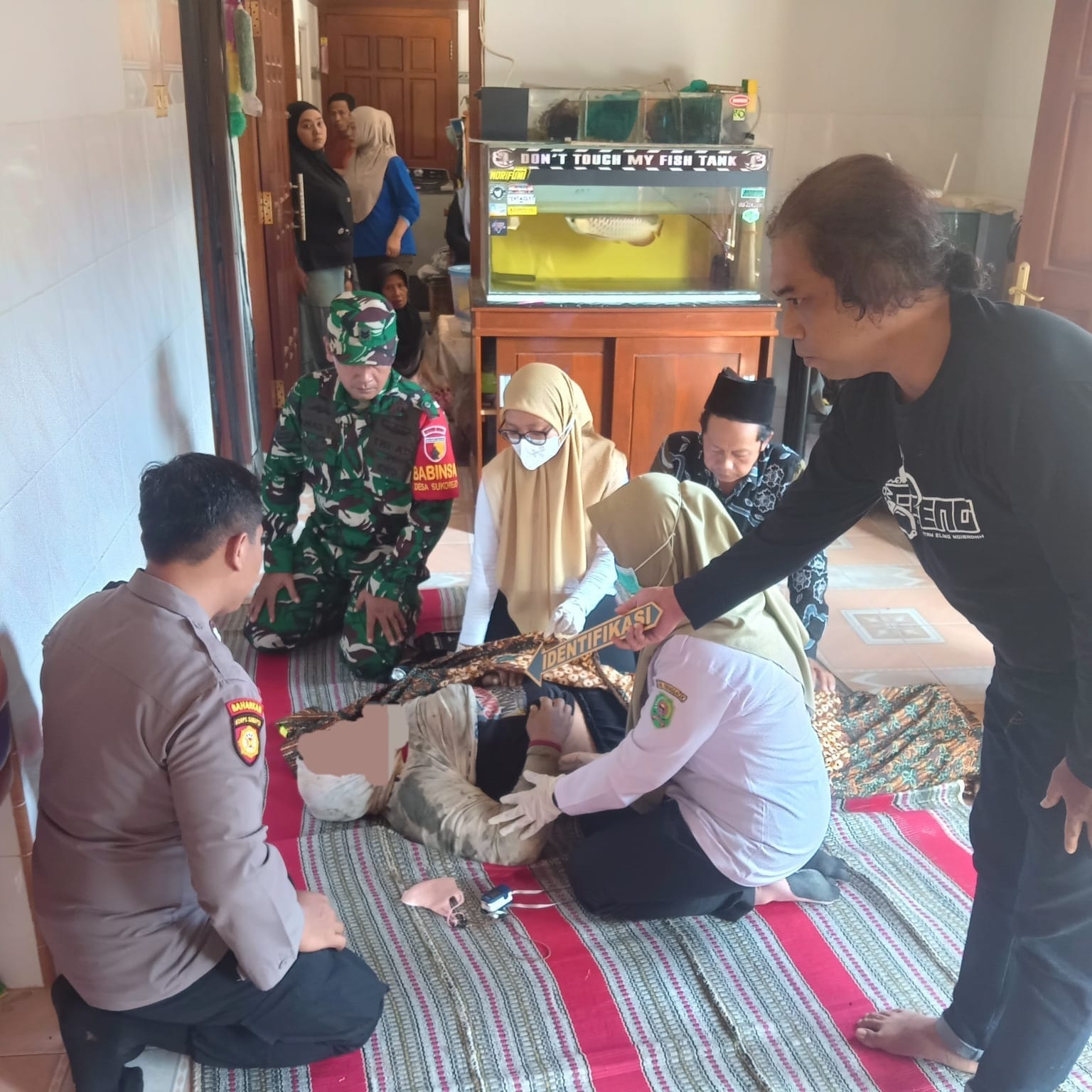 Polisi bersama tim kesehatan melakukan visum terhadap jenazah korban di Desa Sukorejo, Kecamatan Gandusari, Kabupaten Trenggalek, Rabu (24/12/2025).