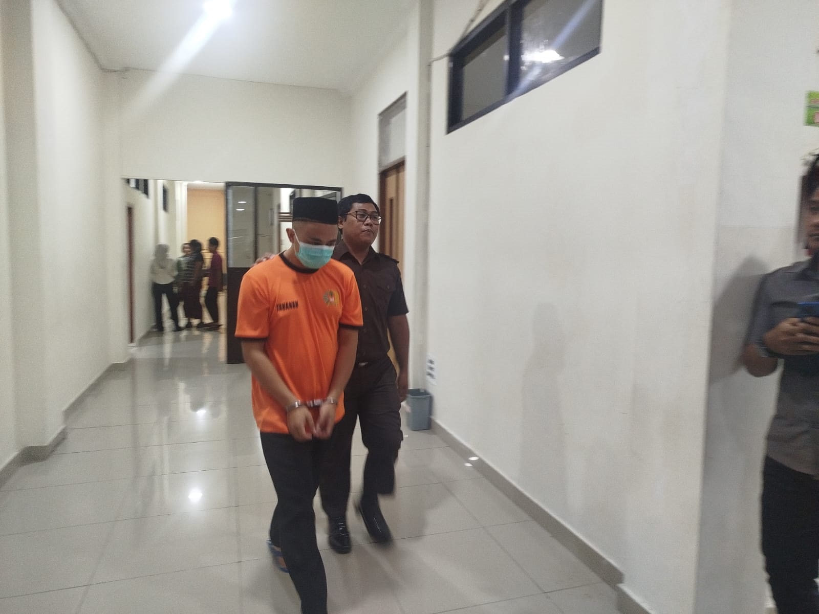 Terdakwa kasus pemukulan guru, Awang keluar ruangan seusai sidang di PN Trenggalek.