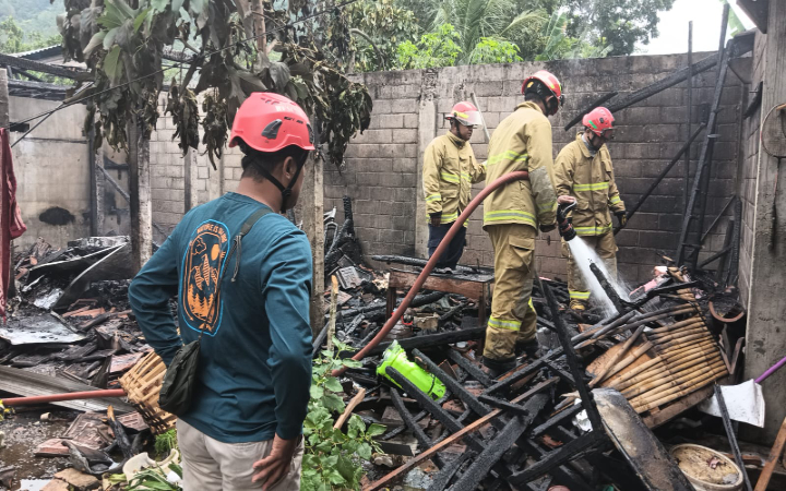 Petugas Damkar Satpol PPK Trenggalek melakukan pendinginan di dapur milik warga Desa/ Kecamatan Pogalan yang terbakar.