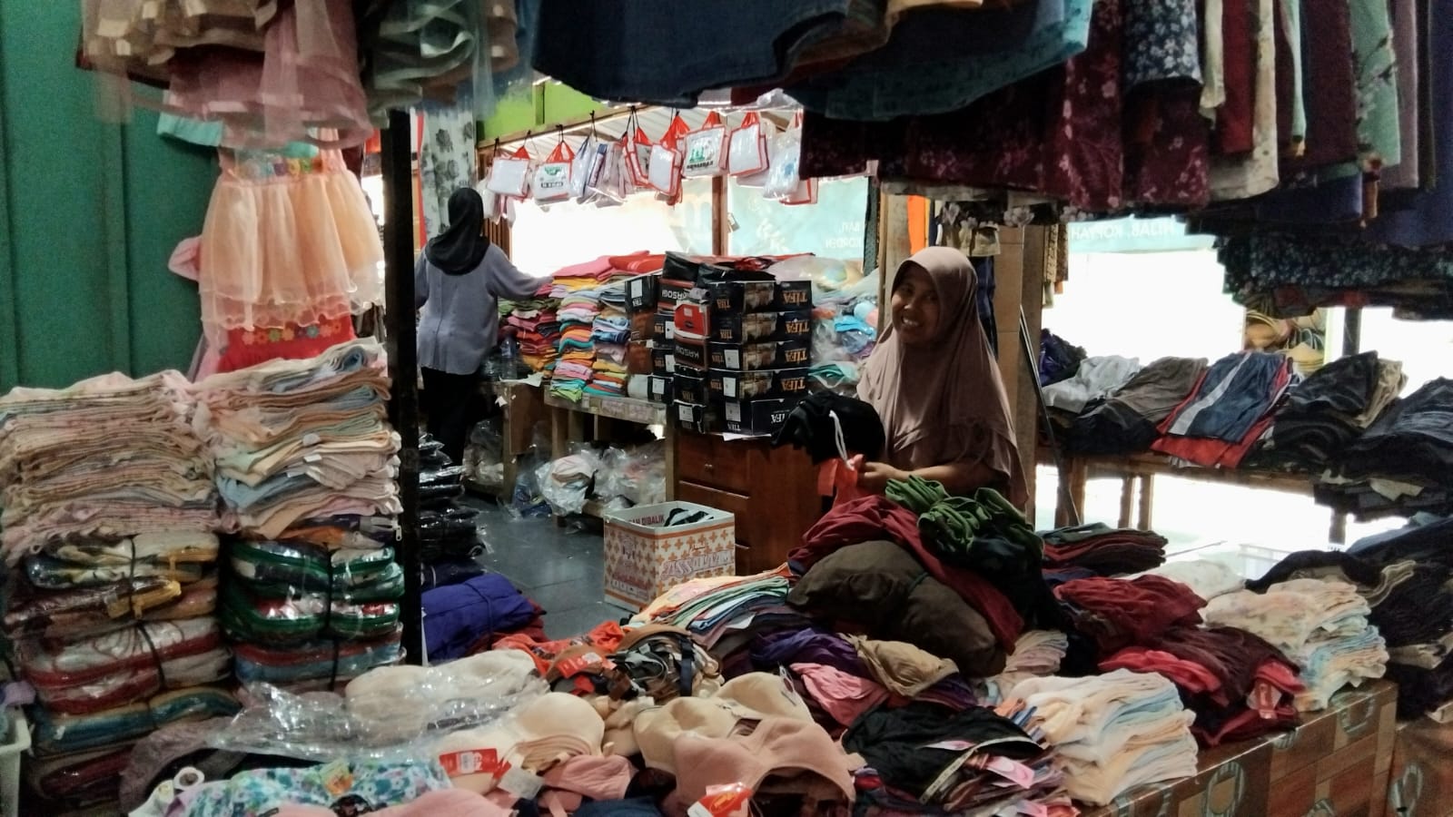 Potret pedagang baju di Pasar Trasdisional sedang merapikan dagangannya