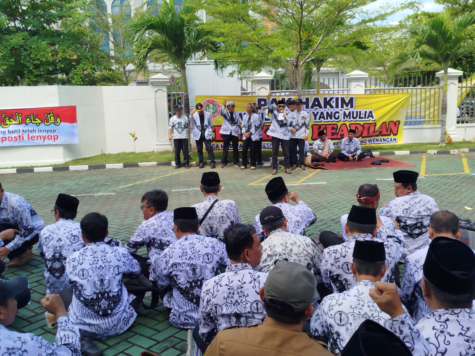 Perwakilan PGRI dari luar daerah dan Trenggalek ketika berorasi di halaman kantor PN sebelum sidang dimulai, Selasa (3/2/2026).