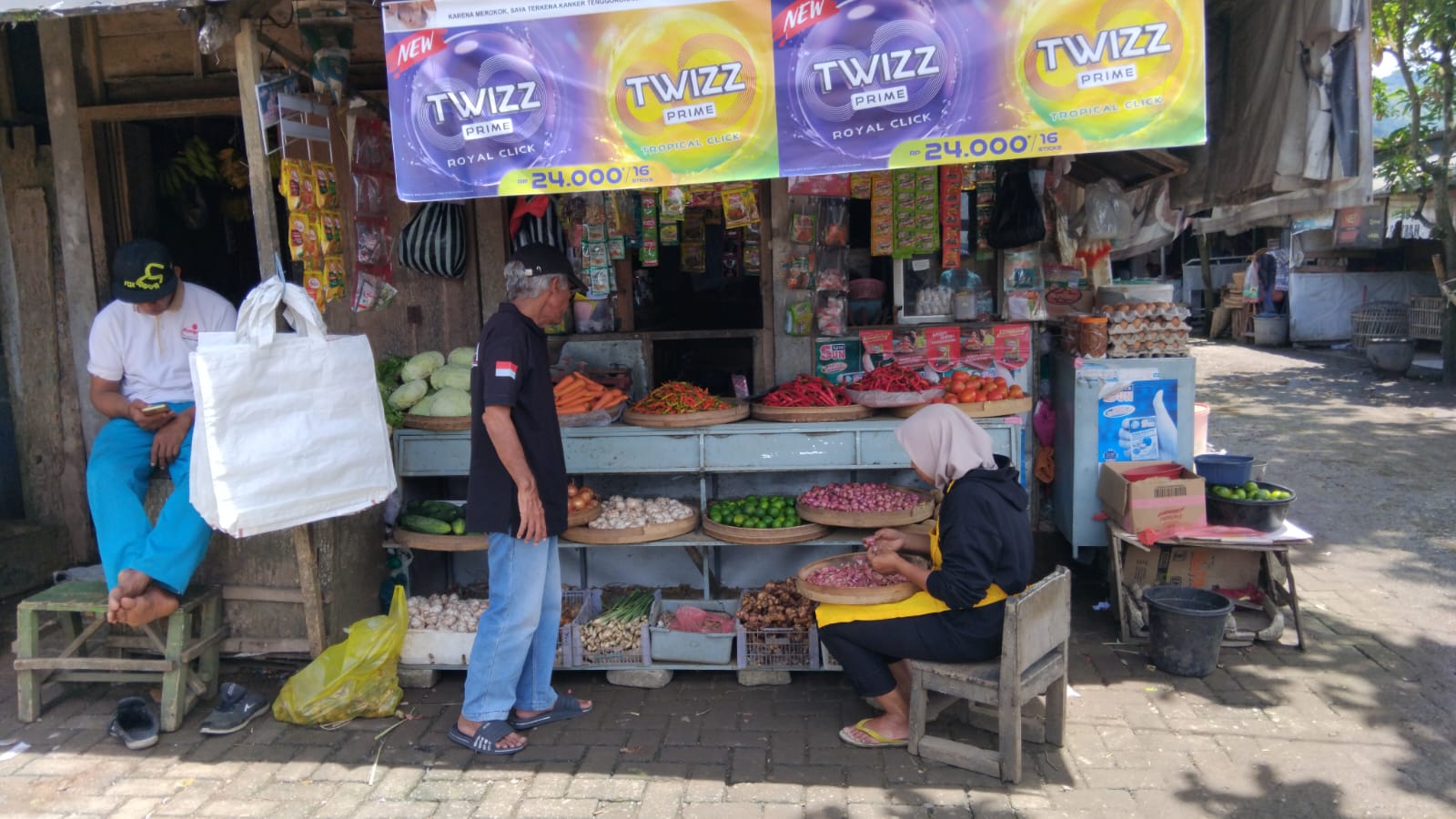 Potret seorang pengunjung pasar sedang menanyakan harga komoditas sembako kepada pedagang