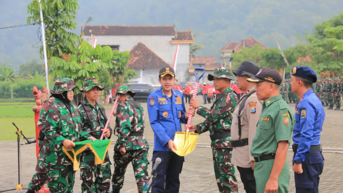 GENJOT INFRASTRUKTUR: Wakil Bupati Trenggalek Syah M. Natanegara saat membuka prrogram TMMD, di Desa Sukorejo,Kecamatan Gamdusari,Rabu (22/4). Foto bawah, pemberian secara simbolis peralatan yang bakal digunakan untuk program tersebut. (FOTO-FOTO: ZAKI JAZAI/RADAR TRENGGALEK)