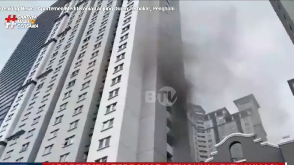 Asap tebal membumbung dari Apartemen Mediterrania Tanjung Duren, Jakarta Barat, saat kebakaran terjadi, petugas mengevakuasi penghuni dari dalam gedung. (YT.BTV)