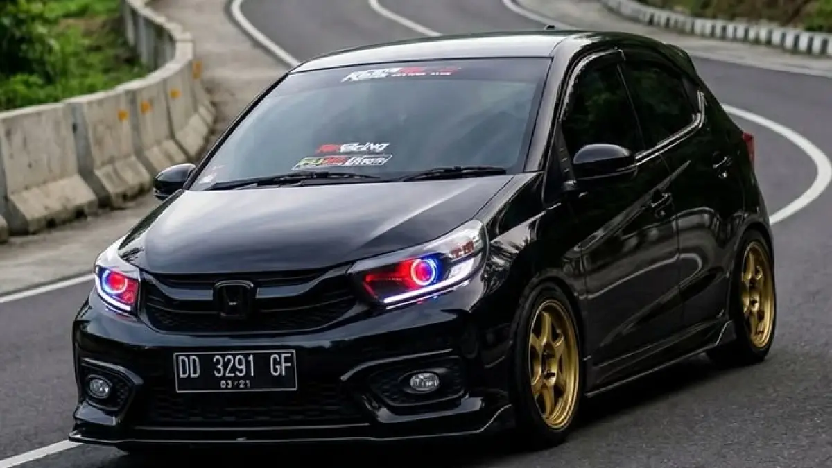 Honda Brio RS mendapat upgrade lampu full custom dengan DRL RGB, fog lamp 2 inci, dan sorotan hingga 75 watt. Simak detailnya.(Gemini AI)