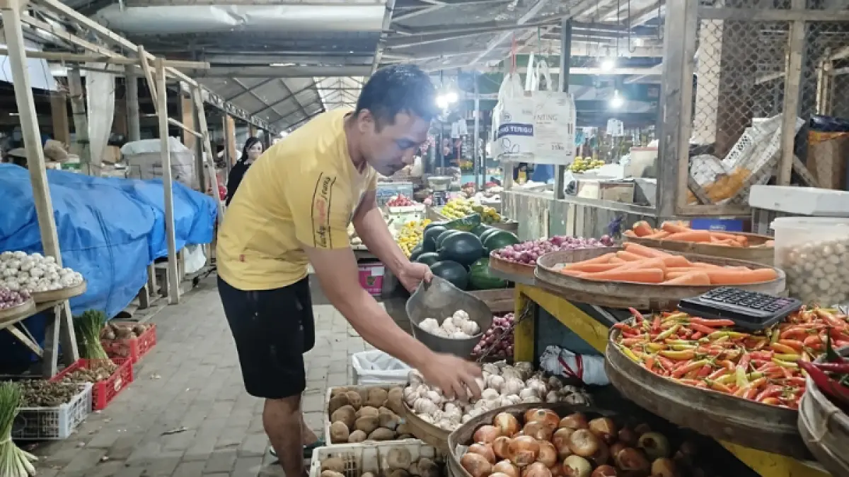 PASOKAN MINIM: Pedagang di pasar basah sedang melayani pembeli bawang putih yang harganya melambung tinggi. (ZAKI JAZAI/ RADAR TRENGGALEK)