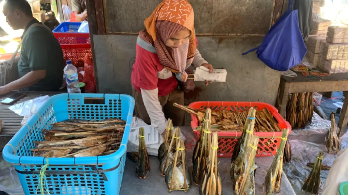 MENGAIS REZEKI: Pedagang ikan asap di Pasar Gandusari terus berharap kondisi ekonomi membaik.(M. BIMA FAISAL/RADAR TRENGGALEK )