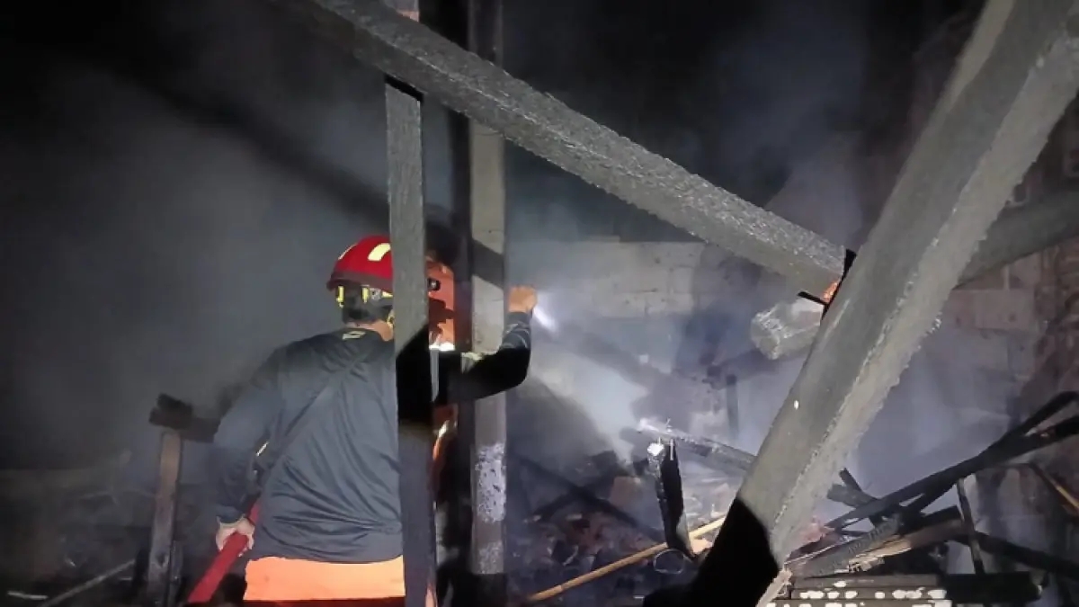 PASTIKAN PADAM: Tim Damkar Satpol PPK Trenggalek melakukan pendinginan pada lokasi kandang ayam dan gudang di Desa Wonocoyo yang terbakar.(Satpol PPK untuk Radar Trenggalek)