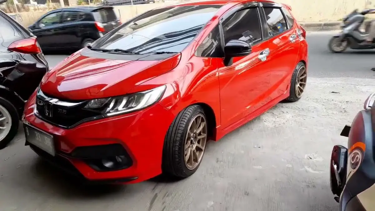 Modifikasi Honda Jazz ring 17 dengan ban 205/45 R17 dan lowering kit bikin tampilan makin sporty, proporsional, serta tetap nyaman dipakai harian. (Youtube. com)
