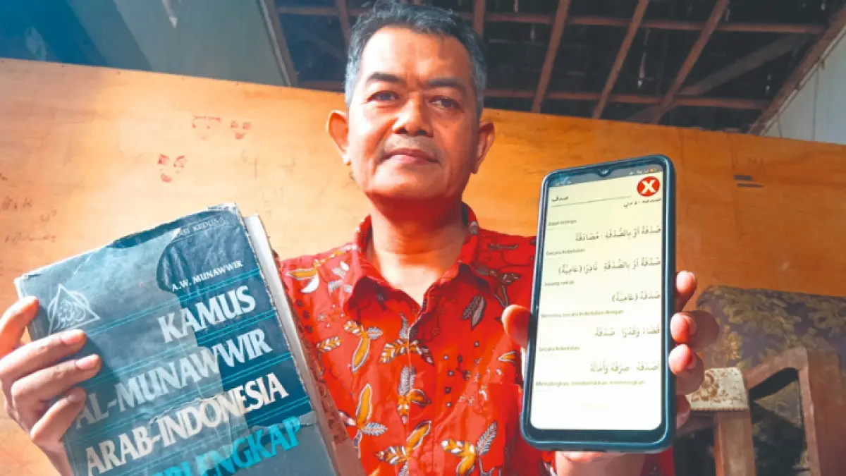 MELEK TEKNOLOGI: Musyafa menunjukan aplikasi Kamus Al Munawwir digital.(Zaki Jazai/ RADAR TRENGGALEK)