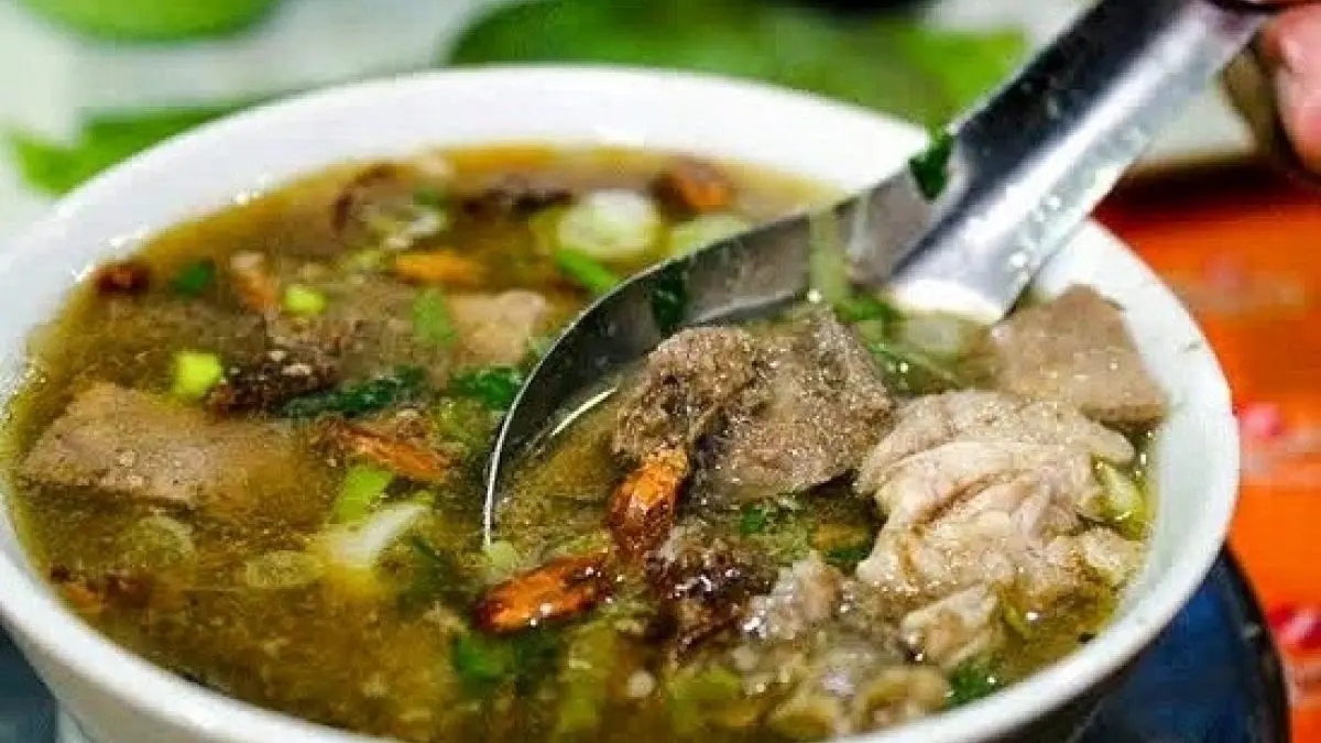Resep Coto Makassar otentik menggunakan air cucian beras, kacang tanah sangrai, dan rempah lengkap. Disajikan bersama buras dan sambal tauco (Pinterest).