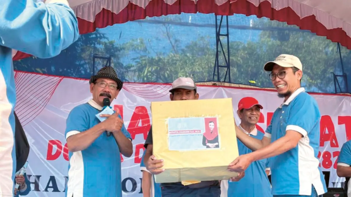 SEMRINGAH: Kepala Dinas Komindag Trenggalek, Saniran, menyerahkan doorprize kepada pemenang undian jalan sehat.(: AMALIA RIZKY IP/RADAR TRENGGALEK)