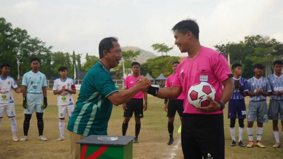 DUKUNG PENUH: Pj Sekda Trenggalek St Triadi Atmono memberikan bola kepada wasit pada upacara pembukaan TSL 2026 di Stadion Menak Sopal, Senin (27/7).(ZAKI JAZAI/ RADAR TRENGGALEK)