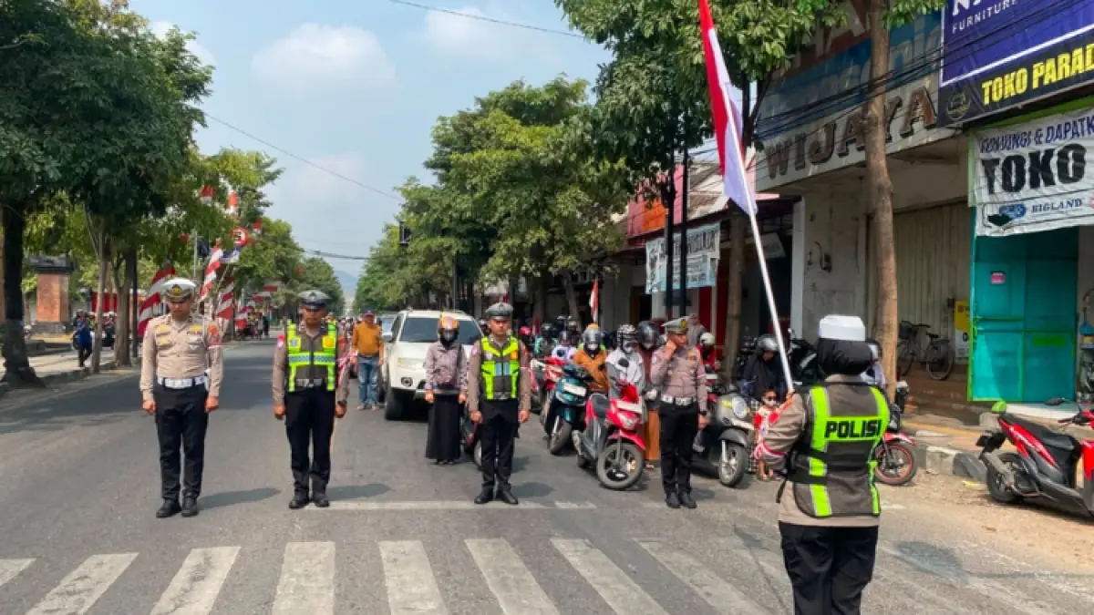 BERI HORMAT: Polisi saat menghentikan para pengguna jalan selama 3 menit untuk memperingati detik-detik proklamasi di simpang empat Pasar Pon, Senin (17/8).(ZAKI JAZAI/ RADAR TRENGGALEK)