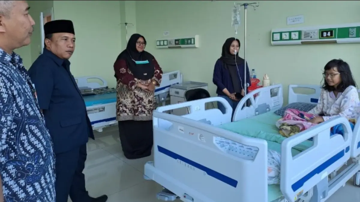 Ketua DPRD Trenggalek Doding Rahmadi saat mengunjungi siswa yang jadi korban permasalahan kesehatan karena di duga keracunan MBG. 