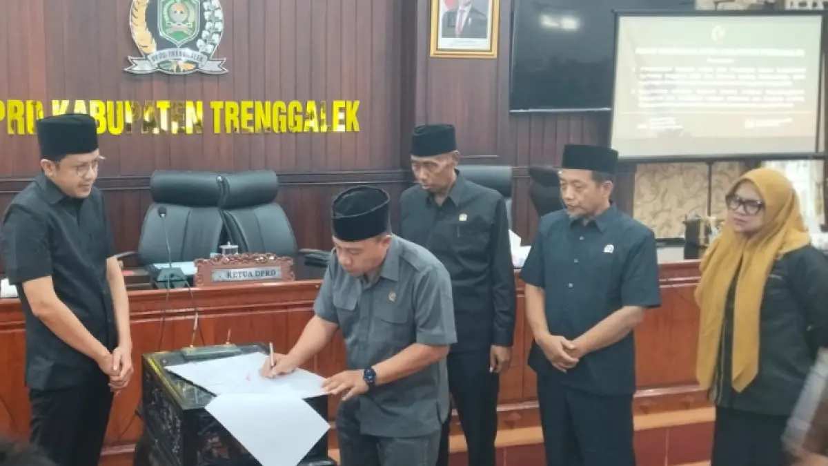 FUNGSI LEGISLASI: Ketua DPRD Trenggalek Doding Rahmadi dan Wakil Bupati Trenggalek Syah M. Natanegara saat penandatanganan pengesahan dua perda di sidang parpurna, Kamis (3/9).(ZAKI JAZAI/ RADAR TRENGGALEK)