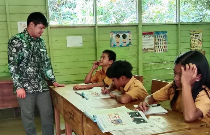 Guru Agama Buddha, Yuyun saat mengajar siswanya di Pedalaman Balangan, Kalimantan Selatan.
