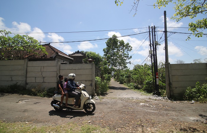 Warga Ungasan melintas di salah satu titik tembok yang dibangun GWK. Saat ini, sudah dibongkar.