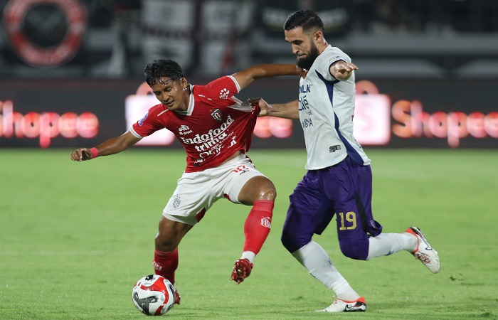 Pemain Bali United Kadek Agung Widnyana Putra (kiri) diganggu pemain  Persita Tangerang Javlon Guseynov. Dalam laga ini kedua tim bermain seri.