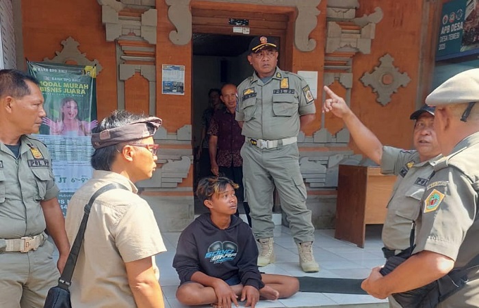 Aparat desa Temesi mengamankan pelaku pembuang sampah sembarangan.