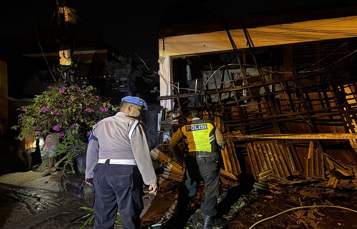 Petugas kepolisian memasang police line di lokasi kebakaran Kebakaran Jalan Gunung Athena II No. 1, Banjar Padang Sumbu Kelod, Desa Padangsambian Kelod, Denpasar.