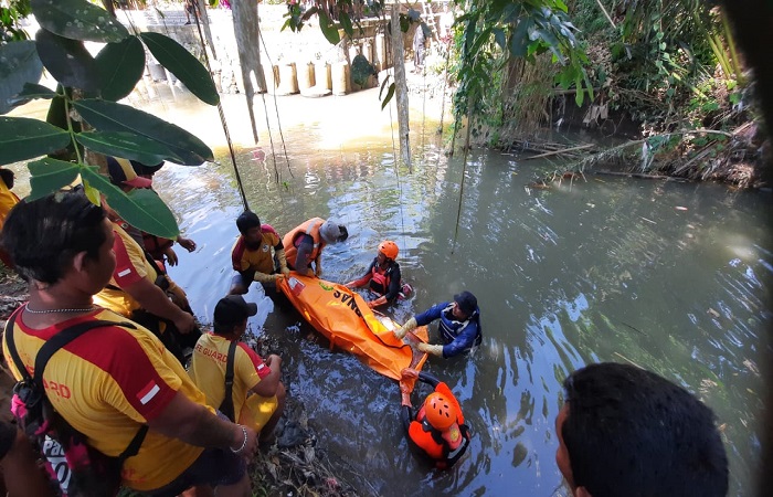 Petugas gabungan mengangkat jasad korban yang hanyut dan ditemukan di Batuan Kaler, Sukawati.