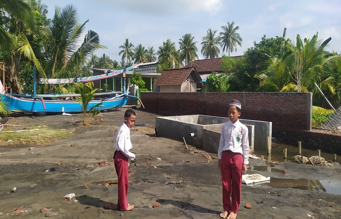 Dua siswa bermain di depan MI Nurul Ikhlas Banjar Pebuahan yang teracam abrasi.