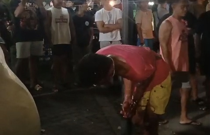 Pria inisial FH, 23, dalam kondisi berlumuran darah dengan posisi terikat di tiang lampu jalan, kawasan Puri Gading, Jimbaran, Kuta Selatan, Sabtu 29 November 2025 lalu.