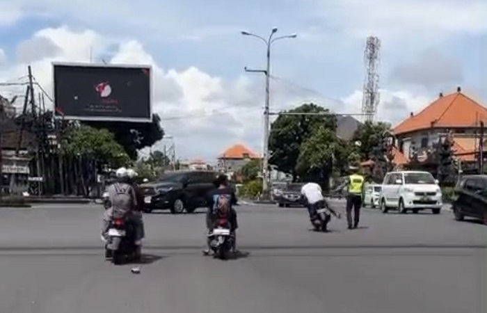 Pengendara motor Suzuki biru&ndash;putih berplat DK 3138 EQ melakukan manuver berbahaya di Simpang Pesanggaran (Benoa), Denpasar Selatan, Senin (8/12) kemarin. Dia nyaris menabrak polisi.