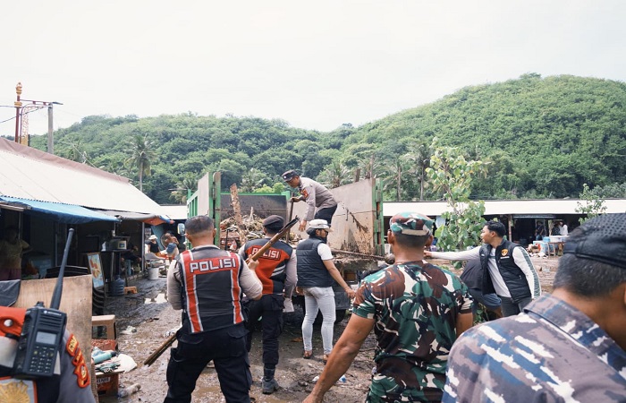 Petugas gabungan membersihkan sisa material karena banjir di pesisir Pantai Crystal Bay, Nusa Penida.