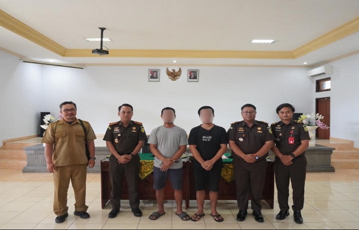 Kedua tersangka inisial M dan FTBU yang mendapat sanksi kerja sosial pilah sampah di TPS3R Desa Bengkel, Kediri Tabanan.