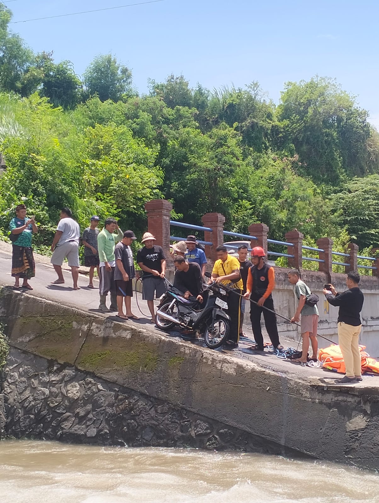 Petugas evakuasi motor yang terjun ke Sungai Unda, Klungkung.