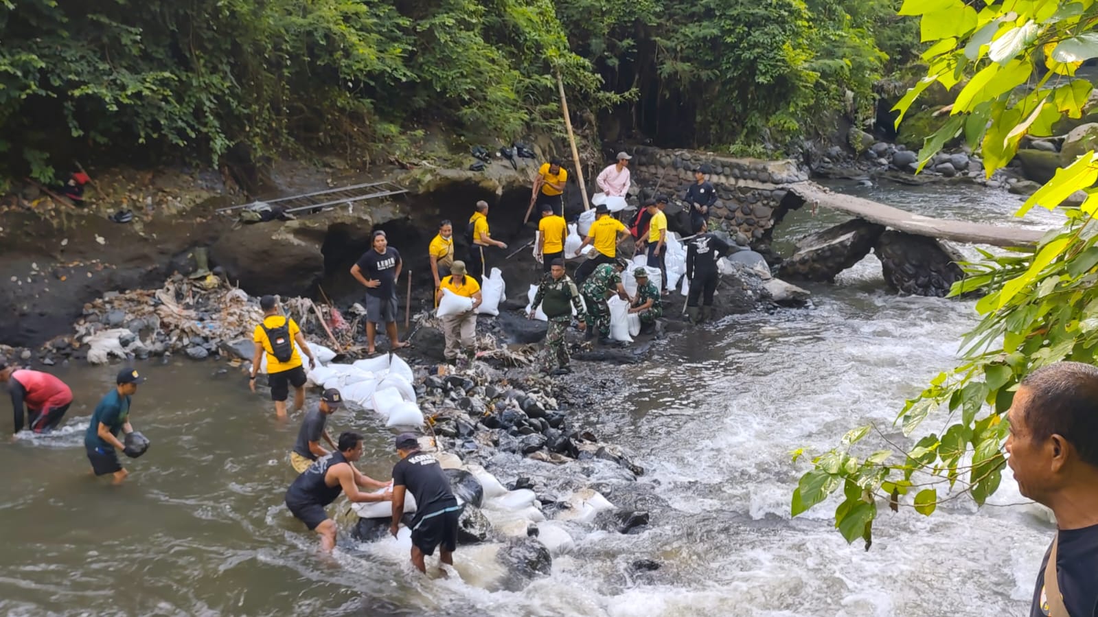 Tanggul bendungan yang jebol ditambal dengan bahan sederhana.