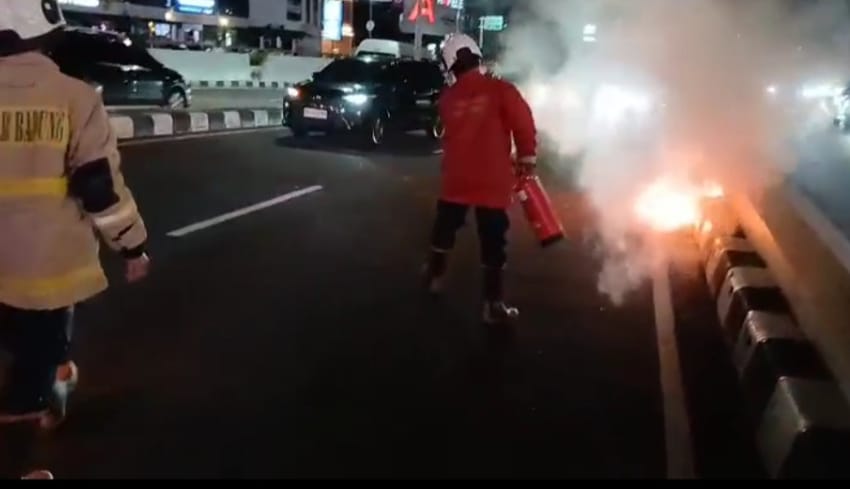 Petugas menangani sepeda motor Yamaha Mio milik seorang pemuda asal Sumba Barat, NTT, hangus terbakar di jalur Underpass Dewa Ruci, Jalan Bypass Ngurah Rai, Kuta, Rabu lalu.